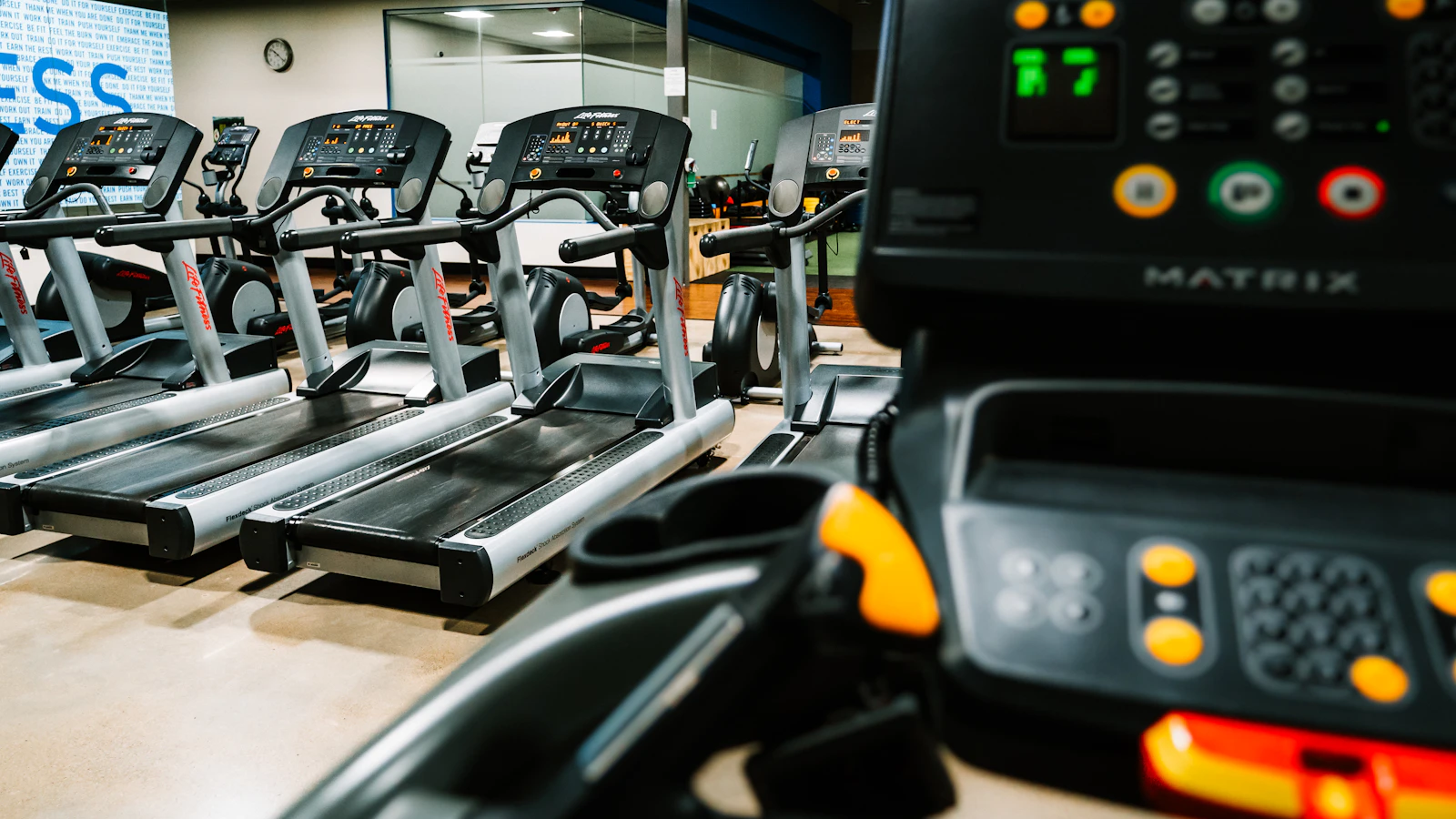 Rij loopbanden en cardioapparaten in een lege sportschool.