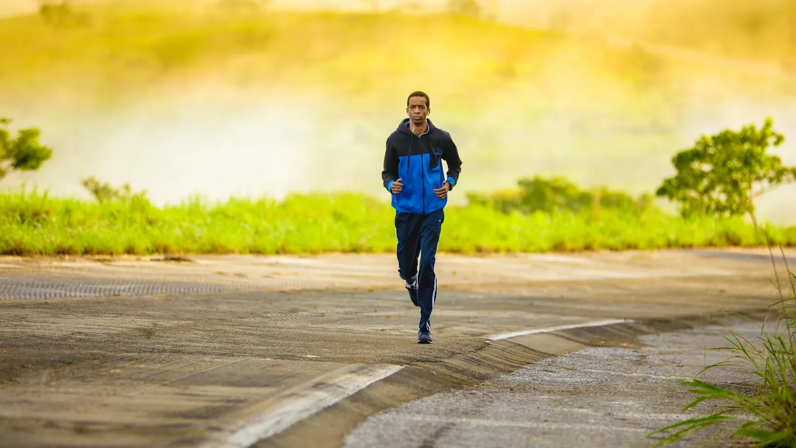 Hardloper in trainingspak op een verlaten weg in de vroege ochtend.