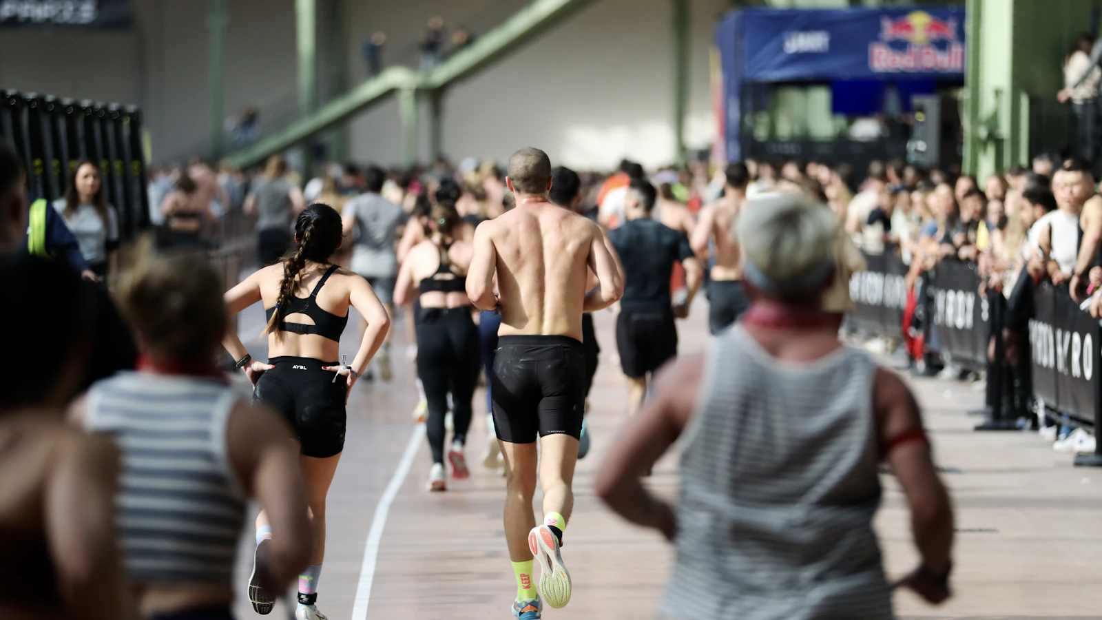 Deelnemers lopen een ronde op het looppad van een Hyrox-wedstrijd.