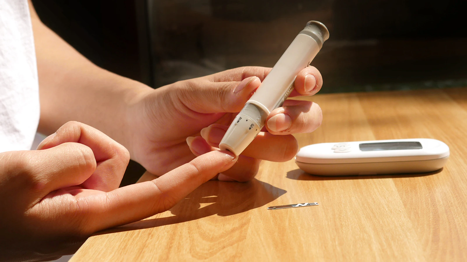 Persoon meet de bloedsuiker met een glucosemeter.