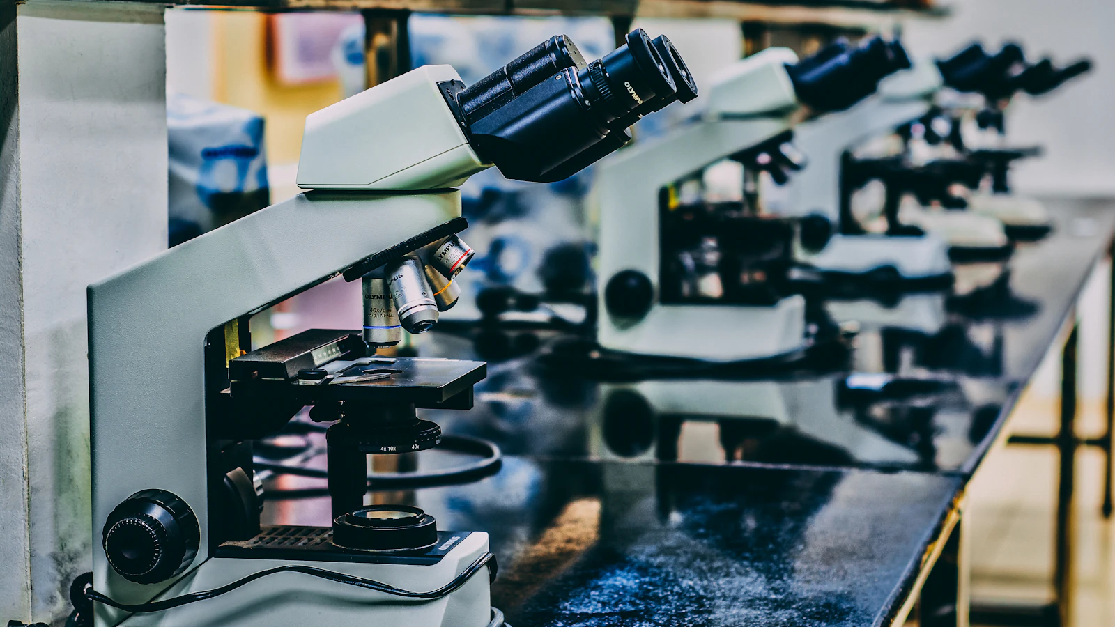 Microscopen staan op een rij op een werkblad in een laboratorium.