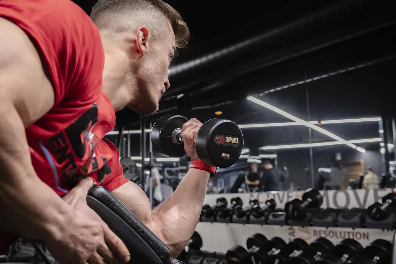 Man tilt een halter tijdens een krachttraining in een sportschool.