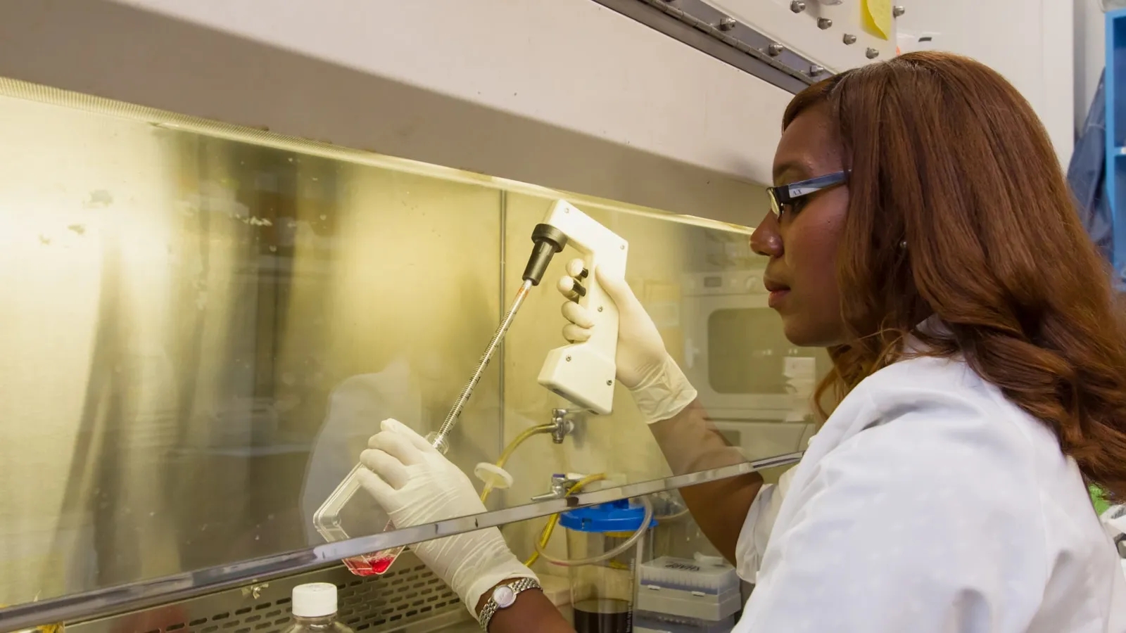 Laborant in witte jas bedient een analyseapparaat in het laboratorium.