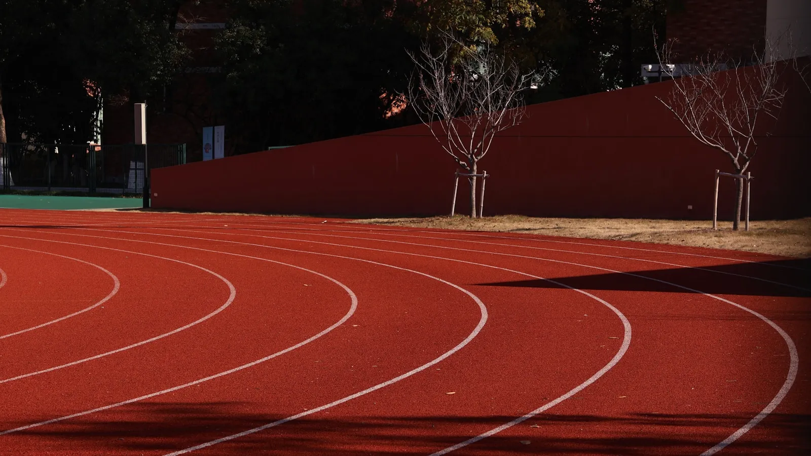 Lege rode atletiekbaan met witte belijning op een koude, heldere dag.
