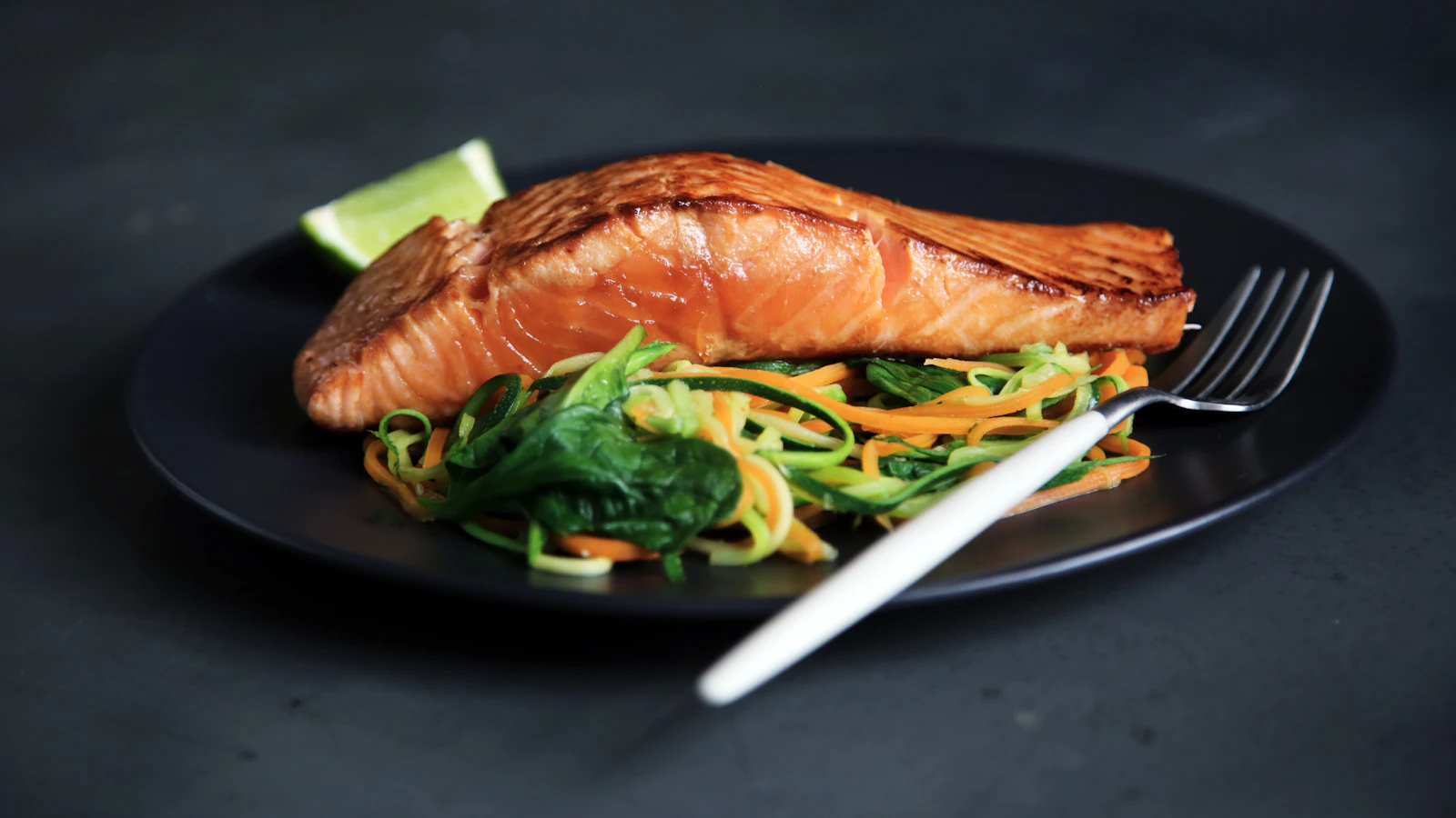 Gegrilde zalm met groenten op een bord.
